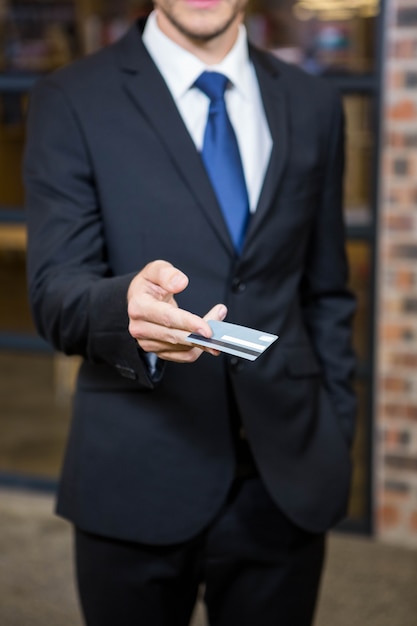 Businessman showing a credit card in office