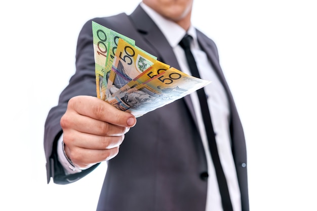 Businessman showing fan of australian dollar banknotes