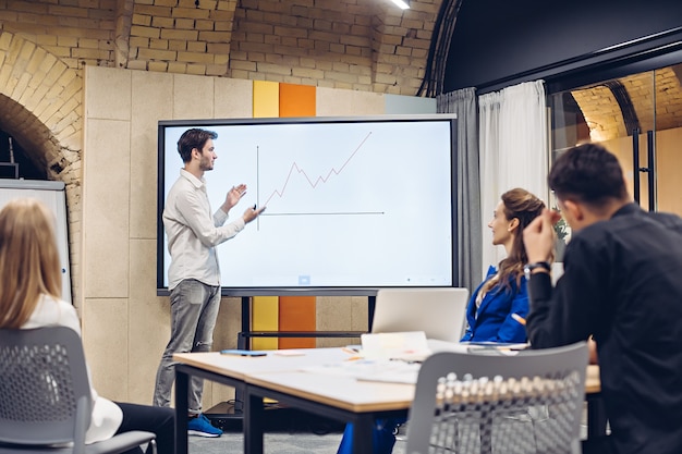 Photo businessman showing growth graph to colleagues