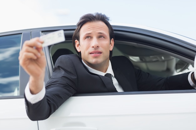 彼の運転免許証を見せているビジネスマン