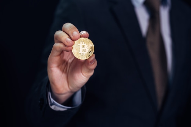 Businessman showing and holding bitcoin sign of coin