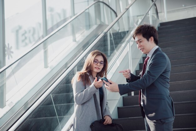 Businessman showing mobile phone to colleague