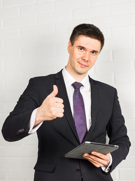 Businessman showing OK sign with his thumb up.