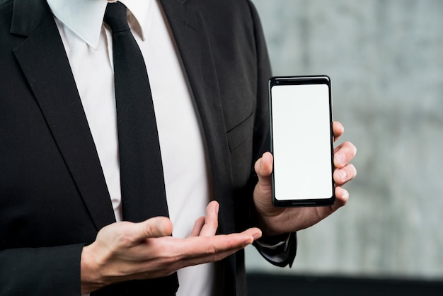 Businessman showing smartphone with empty screen