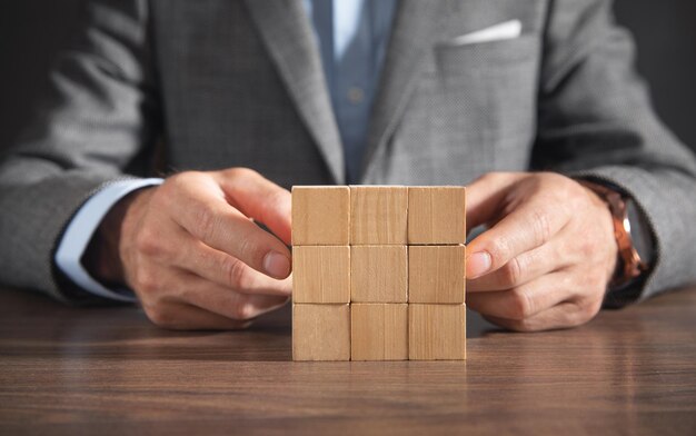 businessman showing wooden empty cubes