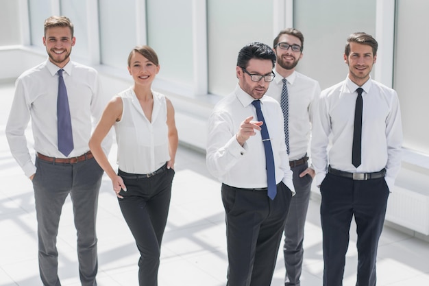 Foto l'uomo d'affari mostra al team aziendale la strada per il successo