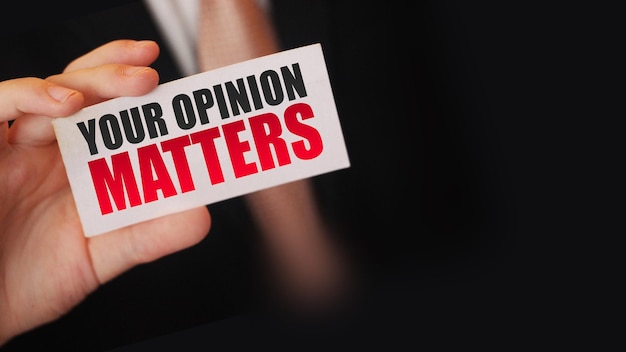 Businessman shows a card with text your opinion matters\
business teambuilding concept