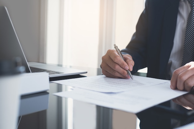 Photo businessman signing business contract at office