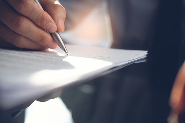 Photo businessman signing business contract in office