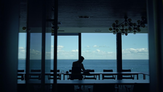 Businessman silhouette reading papers at sea view Lawyer checking documents