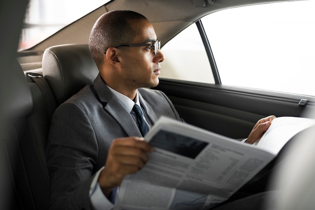 ビジネスマンが車の中の新聞を読む