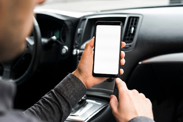 A businessman sitting in the car using mobile phone with white display screen