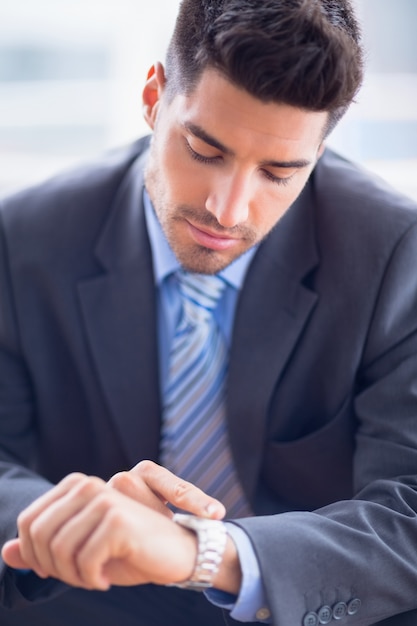 Businessman sitting checking his watch