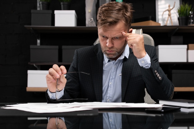 Businessman sitting at computer Desk and thinking about documents