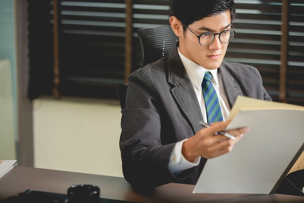 Businessman sitting at desk reading documents