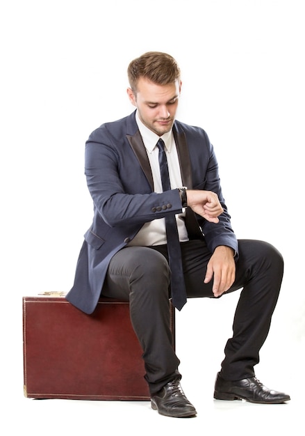 Businessman sitting on his suitcase