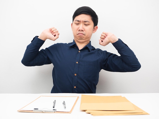 Businessman sitting at his workplace stretch oneself feeling lazy to working