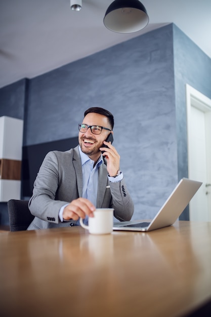 Businessman sitting at home and having a call.