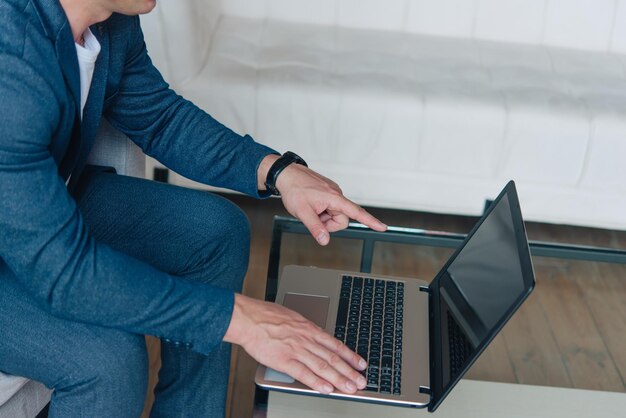 Businessman sitting in an office working with a laptop computer. Business man portrait.