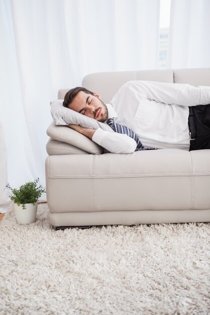 Бизнесмен спит на диване после долгого дня