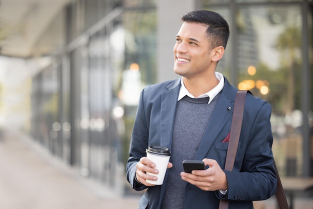 ビジネスマンのスマートフォンの思考と笑顔の使命とソーシャルメディアアプリで歩く街のコーヒー 男の電話と通りにお茶を飲み、金融会社でのキャリアの成功のための幸せなビジョン