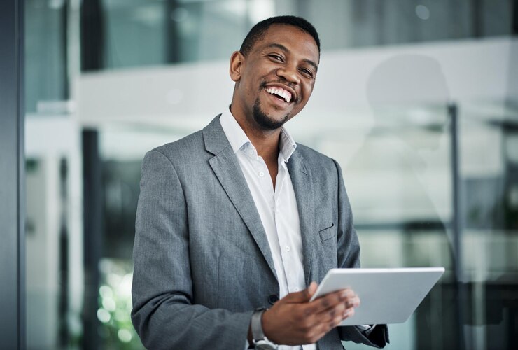Photo businessman smile and portrait with tablet in office for investment research or online finance news financial advisor happy and tech by window for stocks report email or update on company equity
