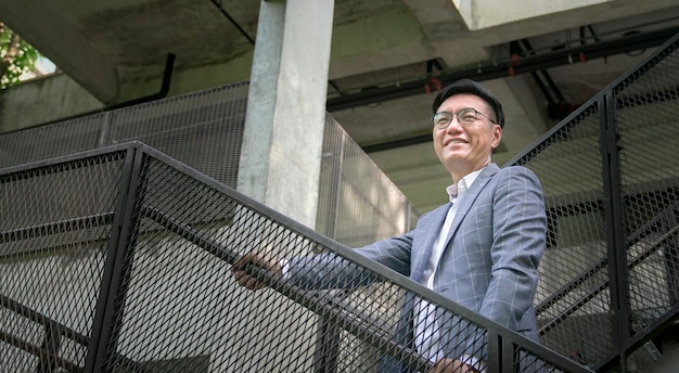 Businessman smiling and hands on the staircase rails