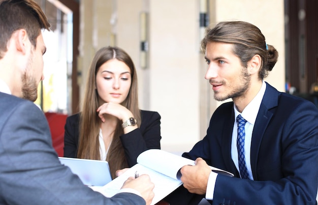 Businessman smiling happily as his business partner finally signing important contract.