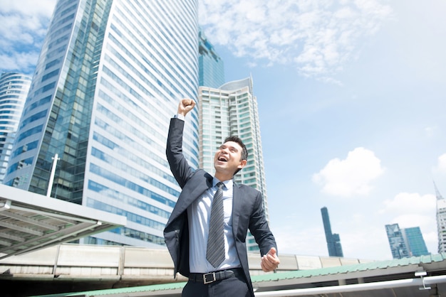 Businessman smiling and raising his fist in the air