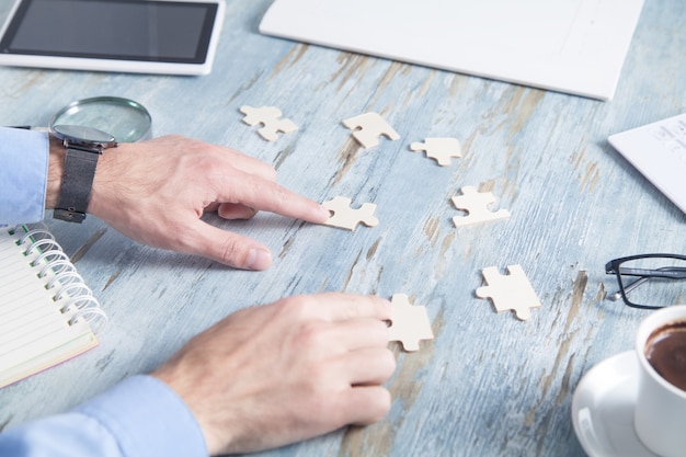 Businessman solving puzzle at the office desk.