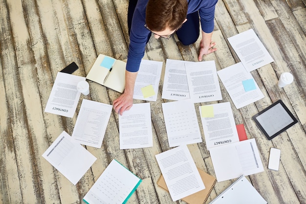 Photo businessman sorting documents on wooden floor