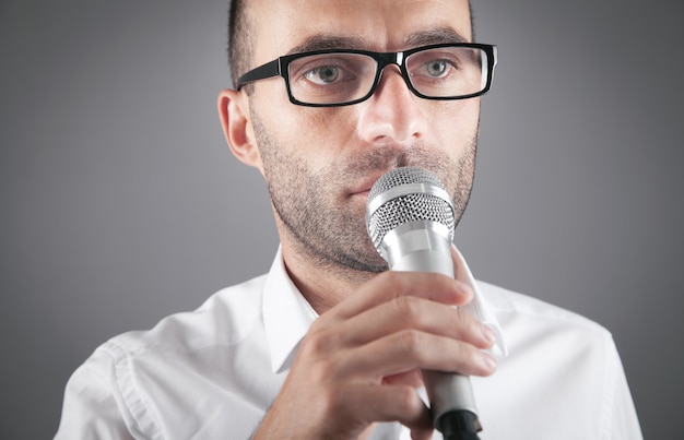 Businessman speaking into microphone in office.