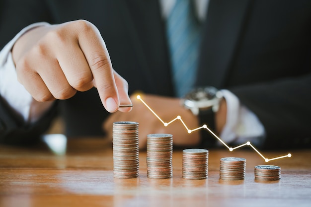 Businessman stacking coins with a graph of profit. Finance Savings concept