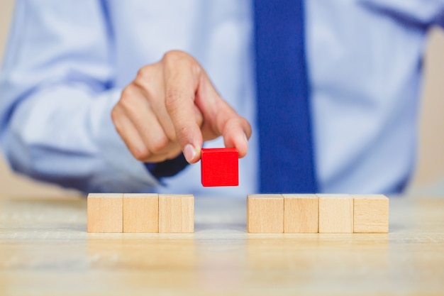 Businessman stacking wooden blocks into steps. concept of business growth success