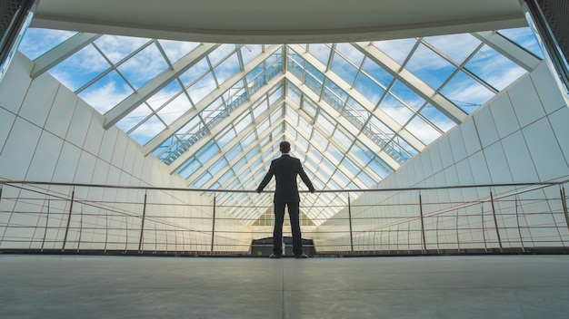 The businessman stand on the bridge in the business center