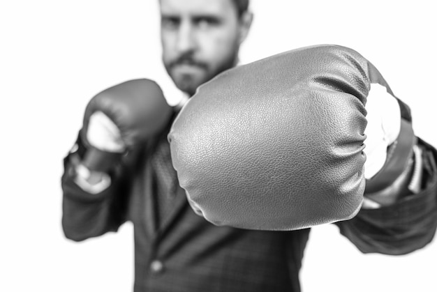 Businessman stand in fighting position wearing blue boxing gloves selective focus punching