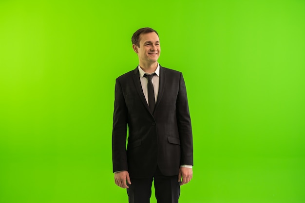 Бизнесмен стоит на зеленом фоне