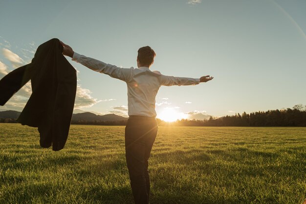 Businessman standing in beautiful green meadow