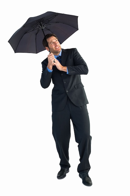 Бизнесмен, стоящий под черным зонтиком