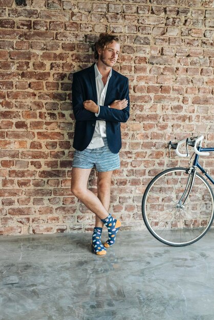 Businessman standing at brick wall wearing jacket and underwear