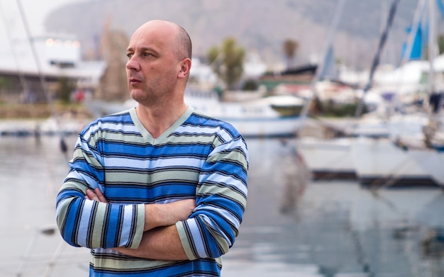 Businessman standing by expensive sailing boats and yachts in a coastal city