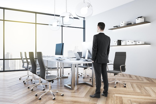 Businessman standing in contemporary coworking office interior