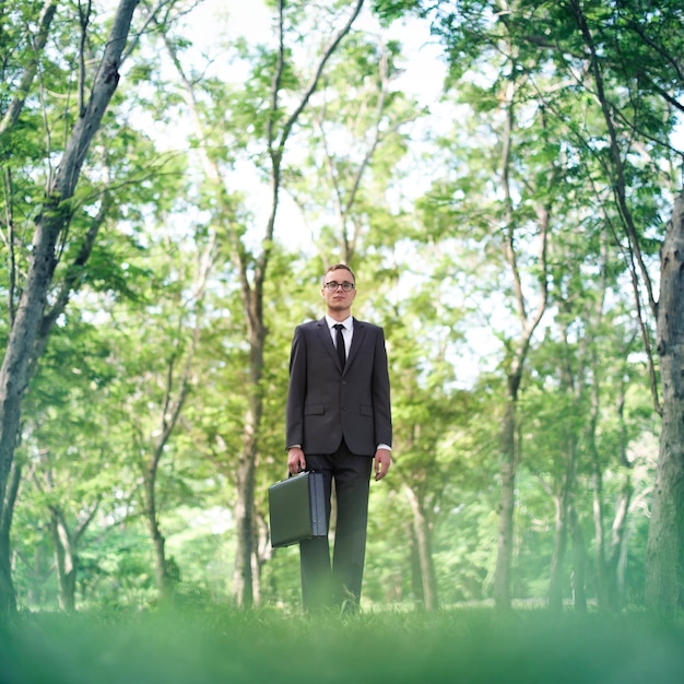 Businessman standing green grass thinking concept