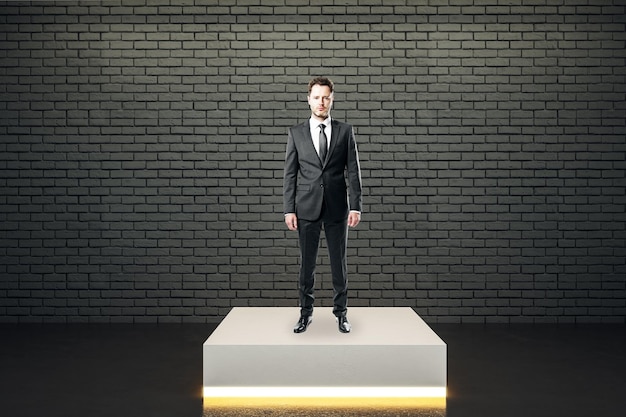 Businessman standing on illuminated pedestal in interior Leadership and success concept