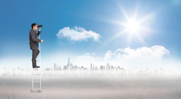businessman standing on ladder against cityscape on the horizon