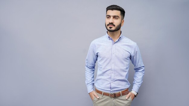 businessman standing looking left in blue shirt with hands in pocket indian pakistani model