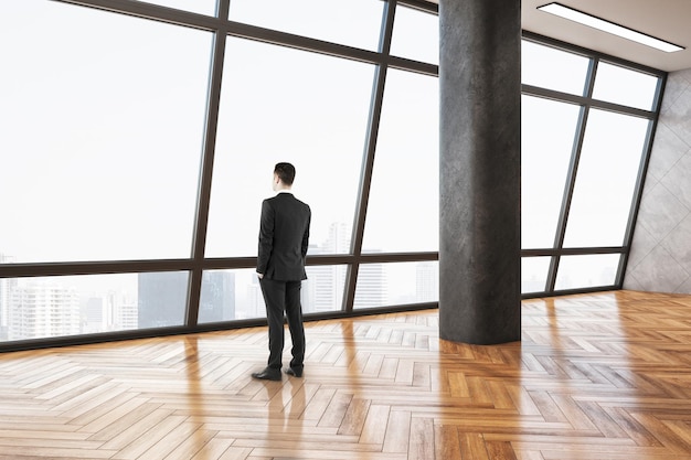 Businessman standing in minimalistic gallery interior