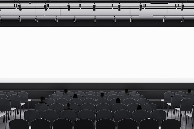 Businessman standing in modern grey auditorium with seating and empty screen with mock up place for your advertisement Show premiere and entertainment concept