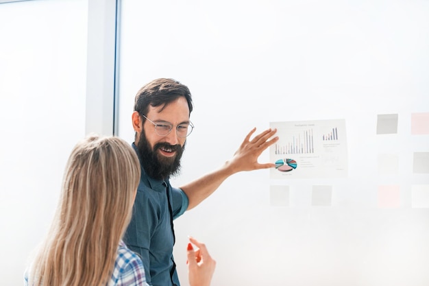 Businessman standing near the board with a financial schedule