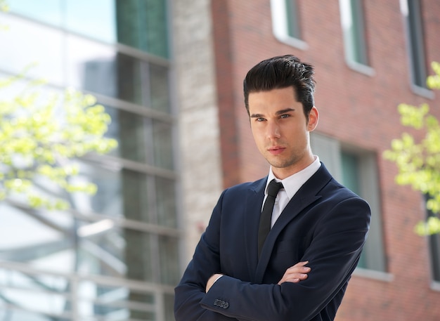 Businessman standing outdoors with arms crossed